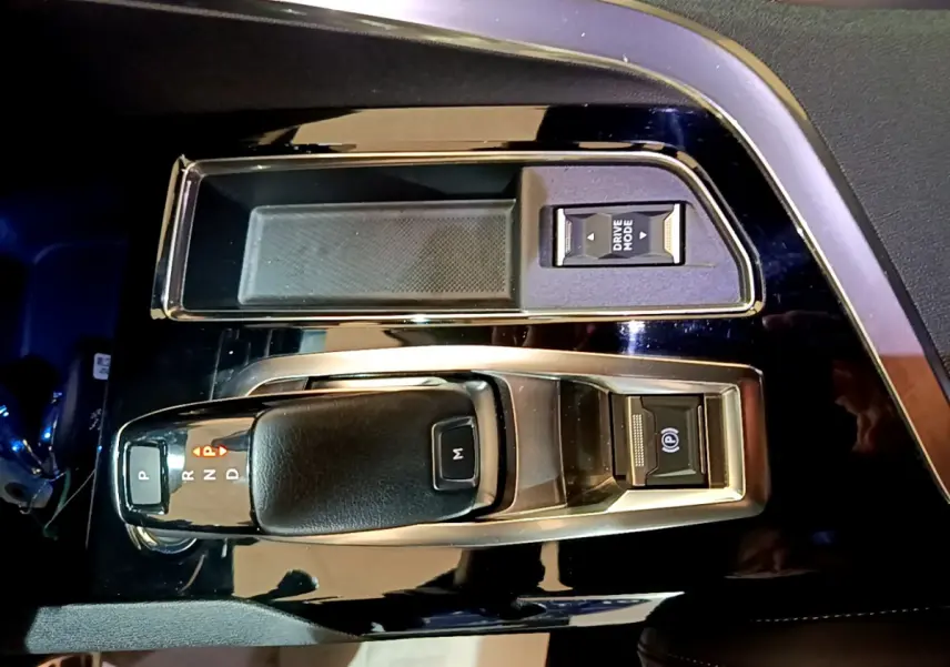 Vue rapprochée de la console centrale noire du Peugeot 3008 GT 2023 avec levier de vitesse et bouton Drive Mode.