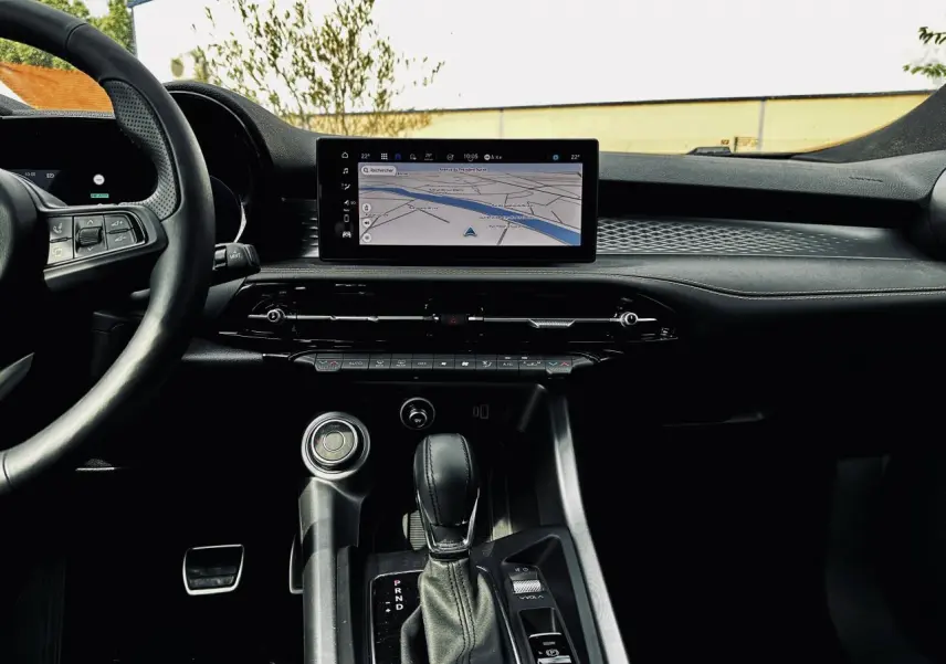 Vue intérieure centrée sur la console centrale et écran tactile du tableau de bord de l'Alfa Romeo Tonale 2024.