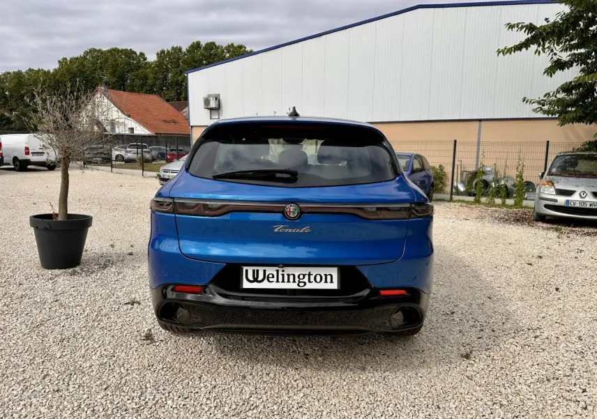 Vue arrière d'une Alfa Romeo Tonale 1.5 mHEV Sprint bleu métallisé, avec feux arrière full LED et double sortie d'échappement noire.