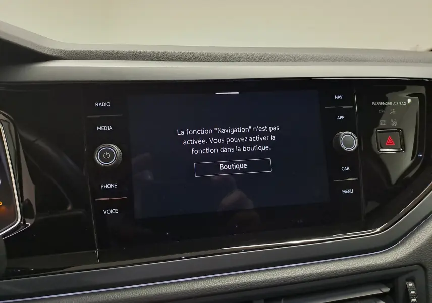 Écran tactile central du Volkswagen Taigo 2025 avec message d'activation de la fonction navigation, entouré de commandes noires.