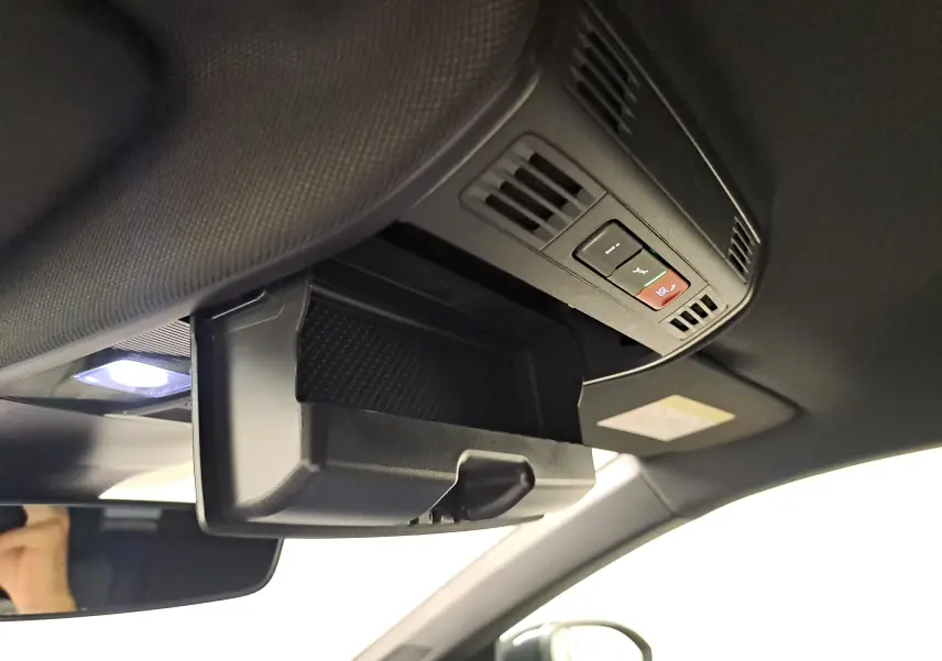 Vue intérieure du coffre à lunettes ouvert au plafond d'un Volkswagen Taigo noir intense, avec commandes intégrées visibles.