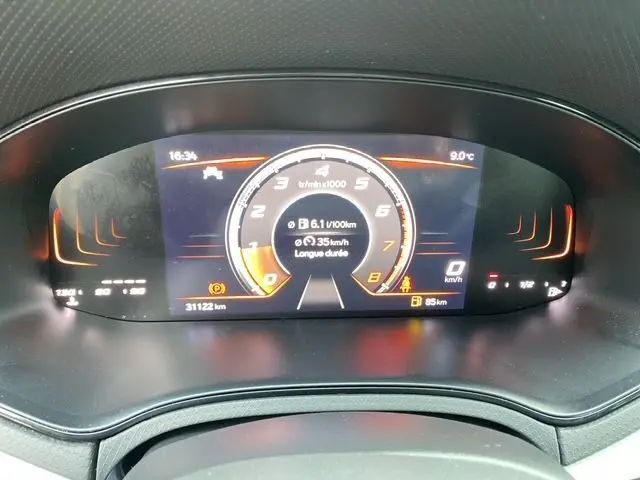 Tableau de bord numérique du SEAT Ibiza 1.0 MPI 80 STYLE 2023 montrant compte-tours, vitesse et consommation à 16h34, 9°C.