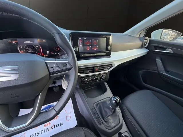 Vue intérieure côté conducteur de la SEAT Ibiza 2023 blanche, avec tableau de bord numérique et écran tactile central.