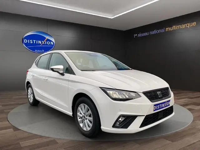 SEAT Ibiza 1.0 MPI 80 Style blanc candy vue 3/4 avant droit en intérieur avec jantes alliage et phares LED.