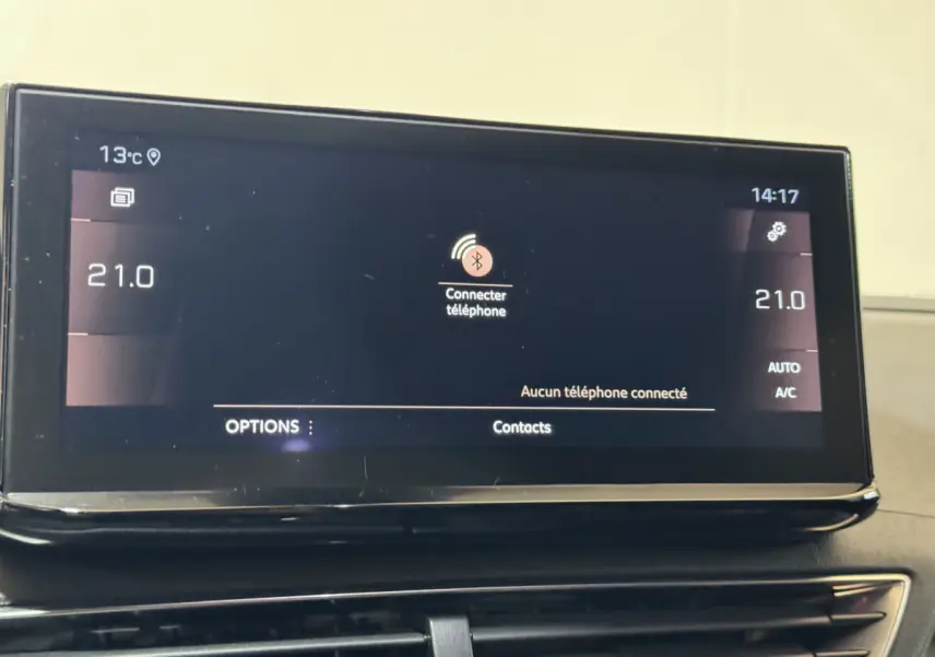 Écran tactile central du tableau de bord du Peugeot 3008 gris clair affichant la connexion Bluetooth et la température à 21°C.