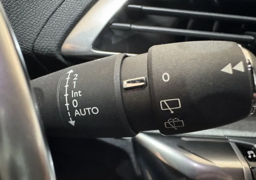 Gros plan sur la commande des essuie-glaces dans l'habitacle noir du Peugeot 3008 gris clair de 2021