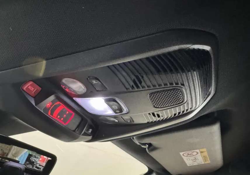 Plafonnier intérieur avec commandes lumineuses et bouton SOS du Peugeot 3008 GT gris clair, vue en contre-plongée.