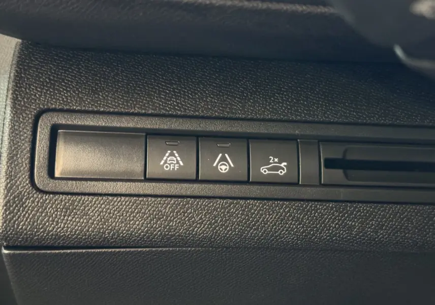 Gros plan sur les boutons de commande d'aide à la conduite dans un Peugeot 3008 gris clair, version GT 2021.