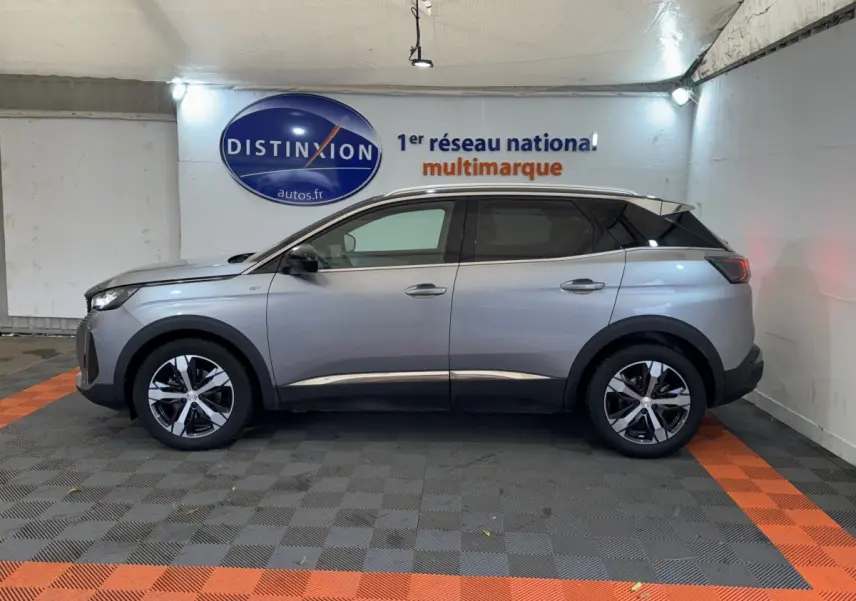 Peugeot 3008 BlueHDi 130 GT gris clair vue de profil côté gauche dans un showroom avec logo Distinxion.