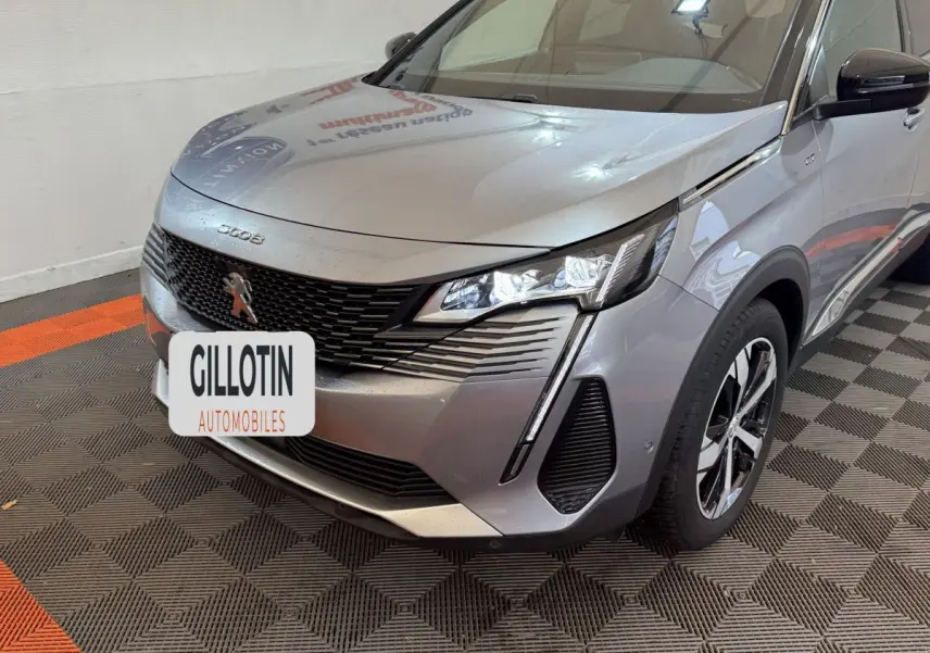 Vue 3/4 avant droit d’un Peugeot 3008 gris clair avec calandre noire et feux LED distinctifs.