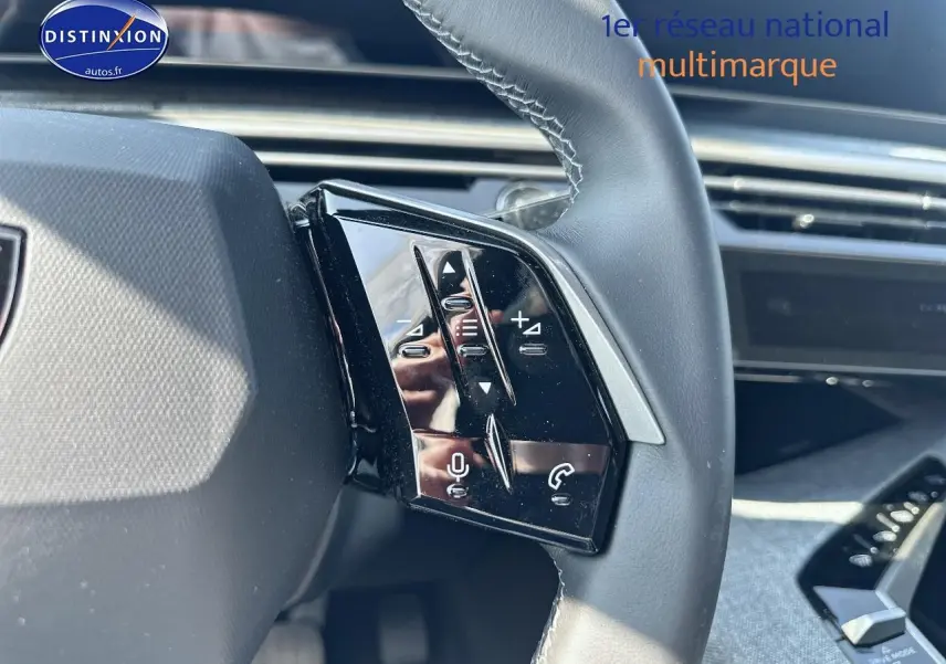 Gros plan sur les commandes multifonctions côté gauche du volant cuir du Peugeot 3008 noir Perla Nera 2025.