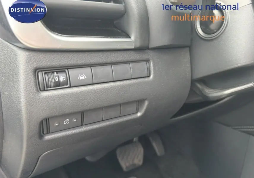 Détail des commandes situées à gauche du volant dans l'habitacle noir du Nissan Qashqai e-POWER 2023.