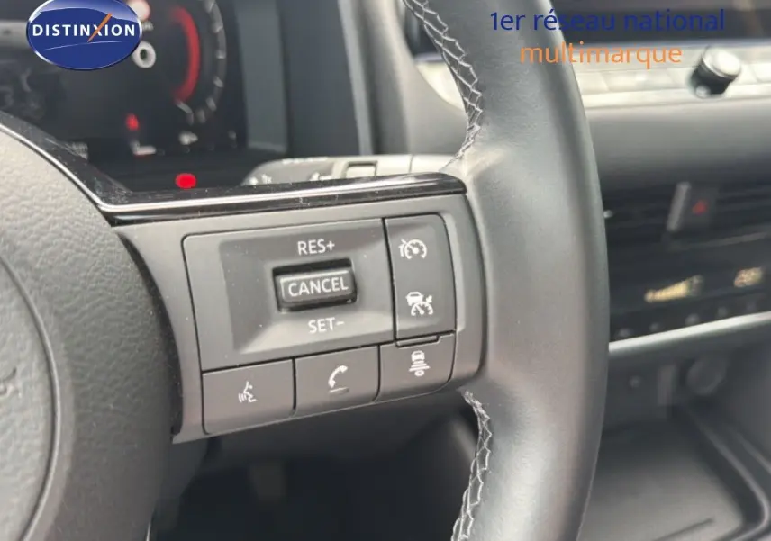 Gros plan sur les commandes au volant du Nissan Qashqai e-POWER 2023, finition Business Edition, intérieur cuir noir.
