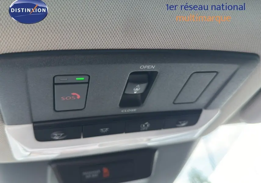 Vue en gros plan du panneau de commandes au plafond intérieur du Nissan Qashqai blanc nacré 2023, avec bouton SOS et commande d'ouverture de toit ouvrant.