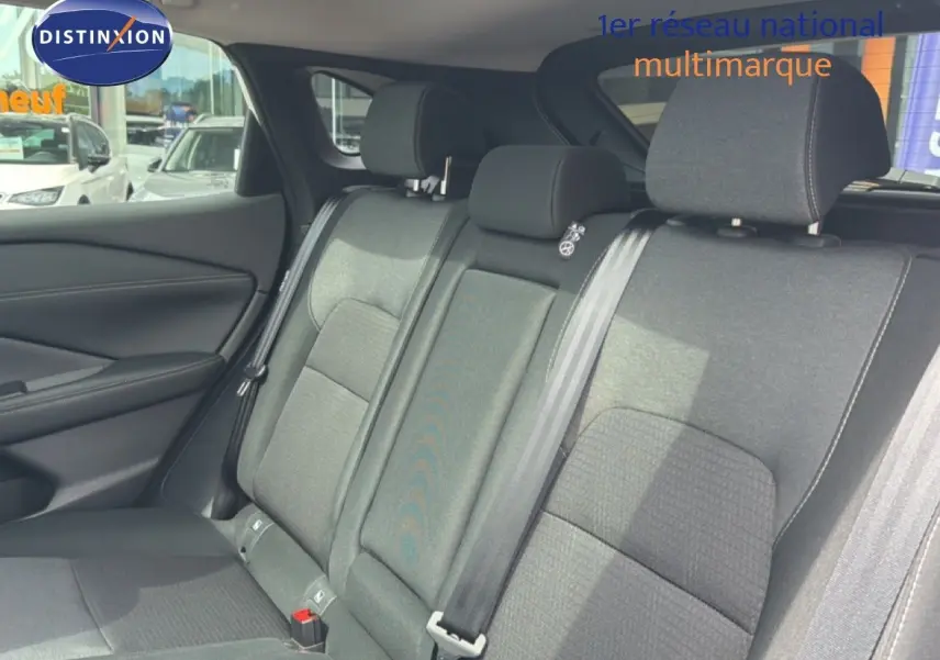 Vue intérieure des sièges arrière en tissu gris du Nissan Qashqai e-POWER 2023, avec ceintures de sécurité visibles.