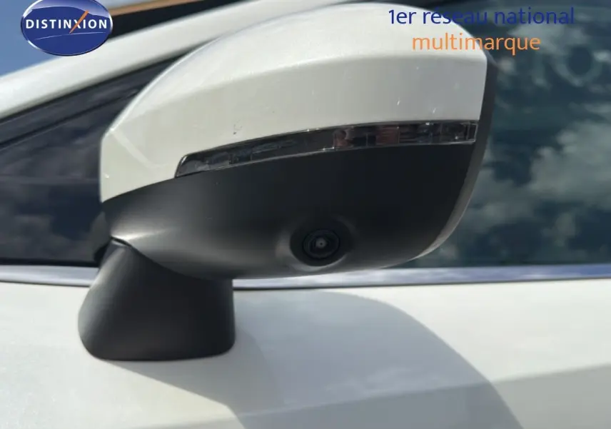 Gros plan sur le rétroviseur blanc nacré du Nissan Qashqai e-POWER 2023 avec caméra intégrée sous la coque noire.