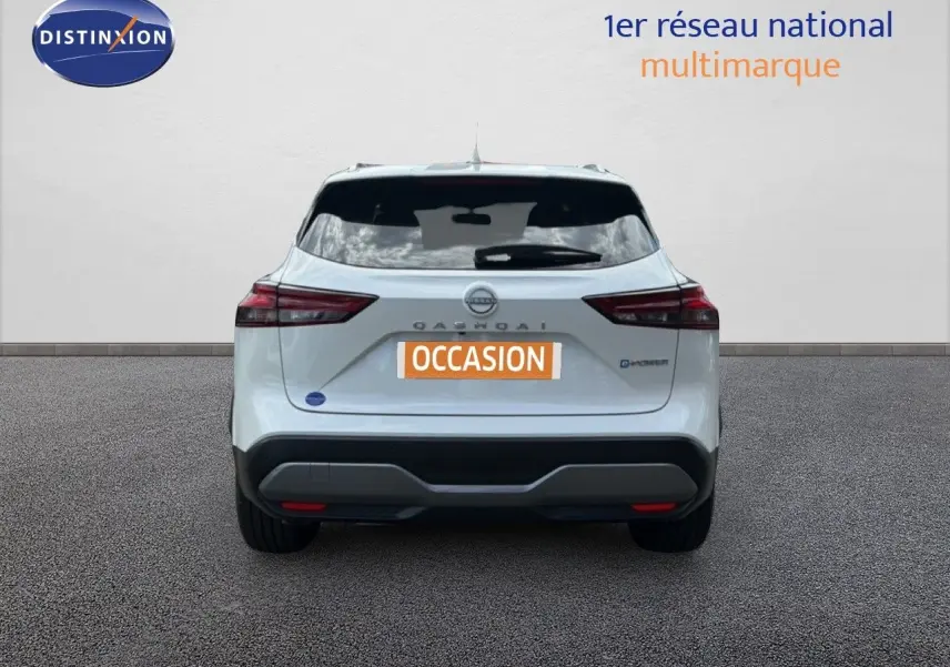 Vue arrière d'un Nissan Qashqai e-POWER blanc nacré métal avec logo et feux arrière distinctifs, sur sol gris.