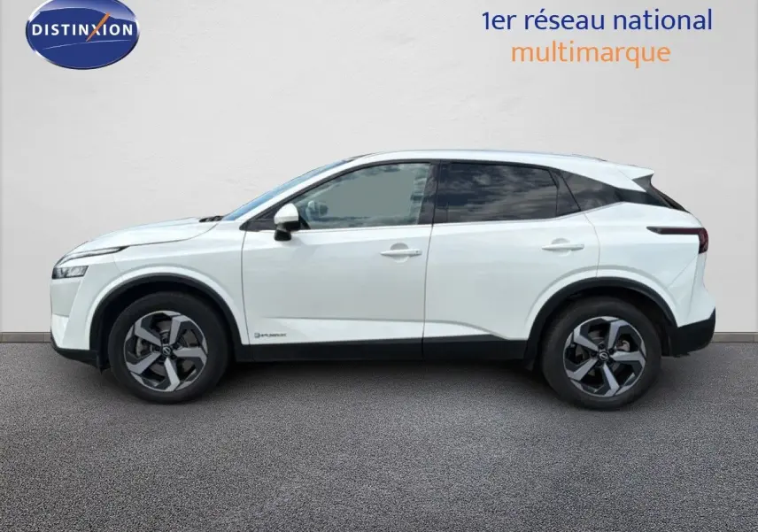 Vue de profil côté gauche d'un Nissan Qashqai e-POWER blanc nacré métallisé avec jantes bi-ton et vitres teintées.