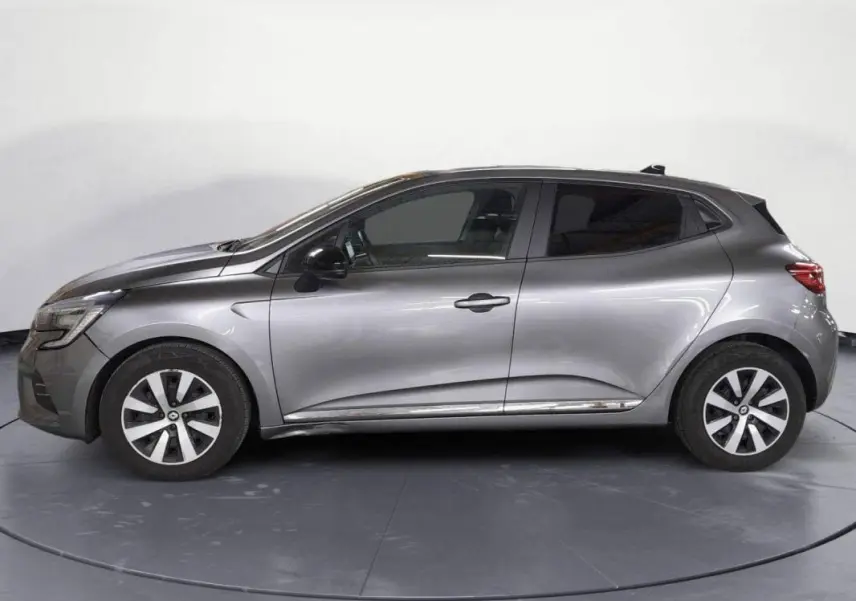 Vue de profil côté gauche d'une Renault Clio V TCe 90 Evolution gris clair de 2023 avec jantes alliage et vitres teintées.