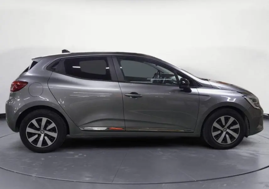 Profil côté gauche d'une Renault Clio V TCe 90 Evolution gris clair de 2023 avec jantes alliage et vitres teintées.
