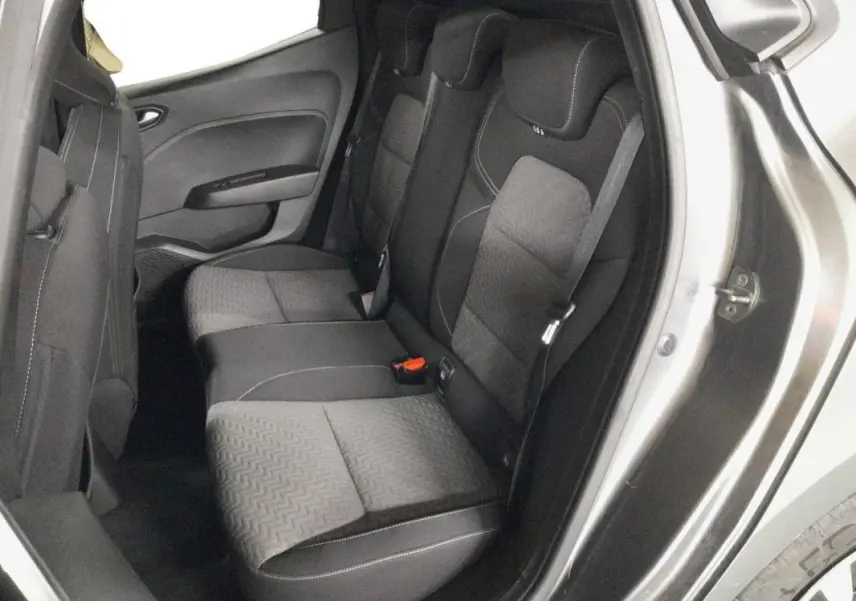 Vue intérieure côté droit sur les sièges arrière gris foncé avec surpiqûres blanches d'une Renault Clio 2023 gris clair.