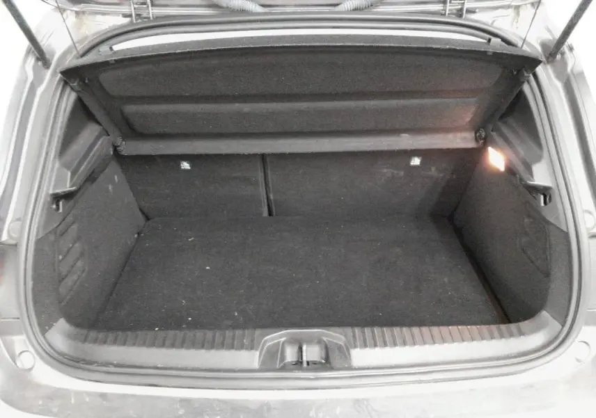Coffre ouvert de la Renault Clio V TCe 90 Evolution gris clair 2023, vue arrière montrant l’espace de chargement vide.