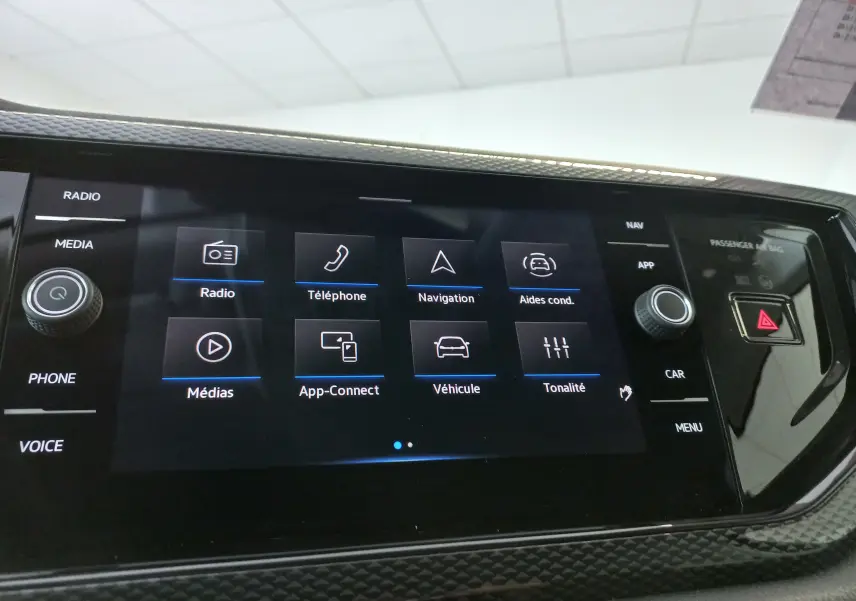 Écran tactile central du Volkswagen Taigo 2025 affichant les options radio, téléphone, navigation et aides à la conduite.