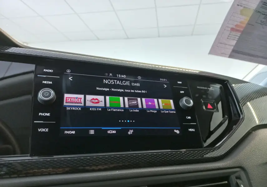 Vue rapprochée de l'écran tactile central du Volkswagen Taigo 2025, affichant la radio numérique avec interface moderne.