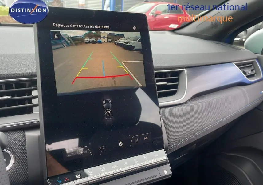 Vue intérieure du tableau de bord du Renault Captur bleu Iron Metal, écran tactile affichant la caméra de recul en marche.
