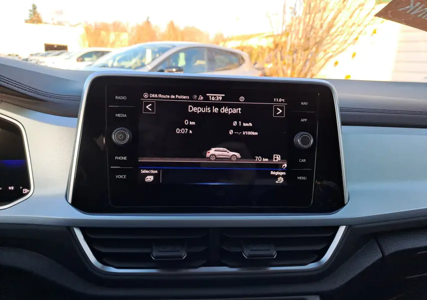 Vue intérieure du tableau de bord du Volkswagen T-Roc 2025 avec écran central tactile affichant les données de trajet.