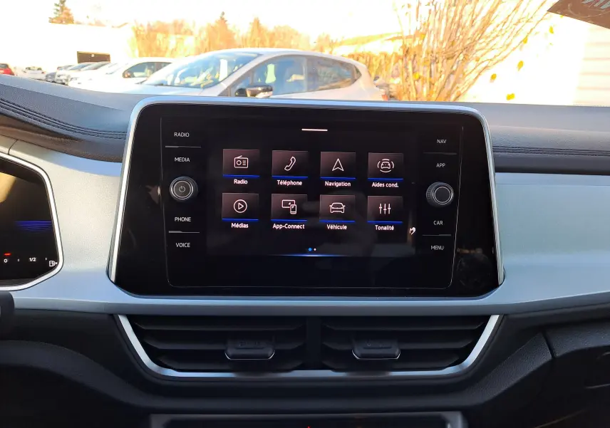 Écran tactile central du tableau de bord du Volkswagen T-Roc gris Ascot, affichant le menu principal multimédia.