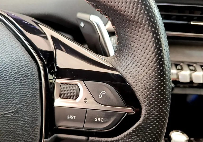 Gros plan sur la commande gauche du volant cuir perforé du Peugeot 3008 GT 2021, boutons appel et volume.