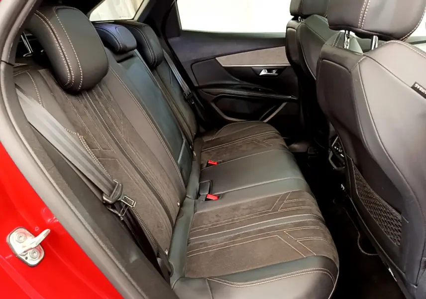 Vue côté gauche des sièges arrière en cuir noir et alcantara du Peugeot 3008 GT rouge, avec ceinture de sécurité visible.