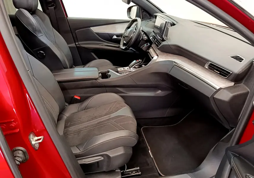 Intérieur avant droit du Peugeot 3008 GT rouge 2021, sièges cuir et alcantara, tableau de bord moderne avec écran tactile.