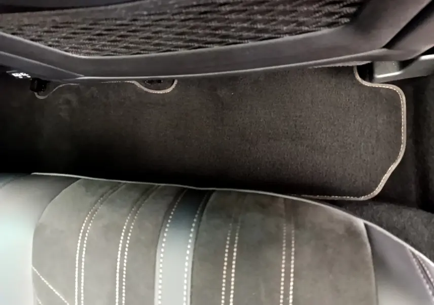 Vue rapprochée du tapis de sol et de la partie inférieure du siège avant côté droit dans un Peugeot 3008 GT rouge.