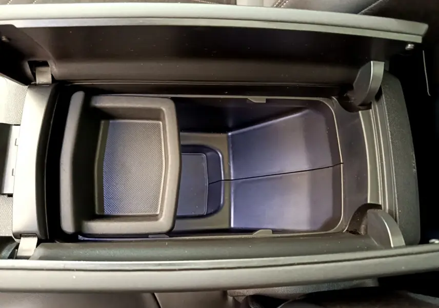 Vue plongeante sur le rangement central noir du Peugeot 3008 GT 2021, mettant en valeur son espace intérieur fonctionnel.