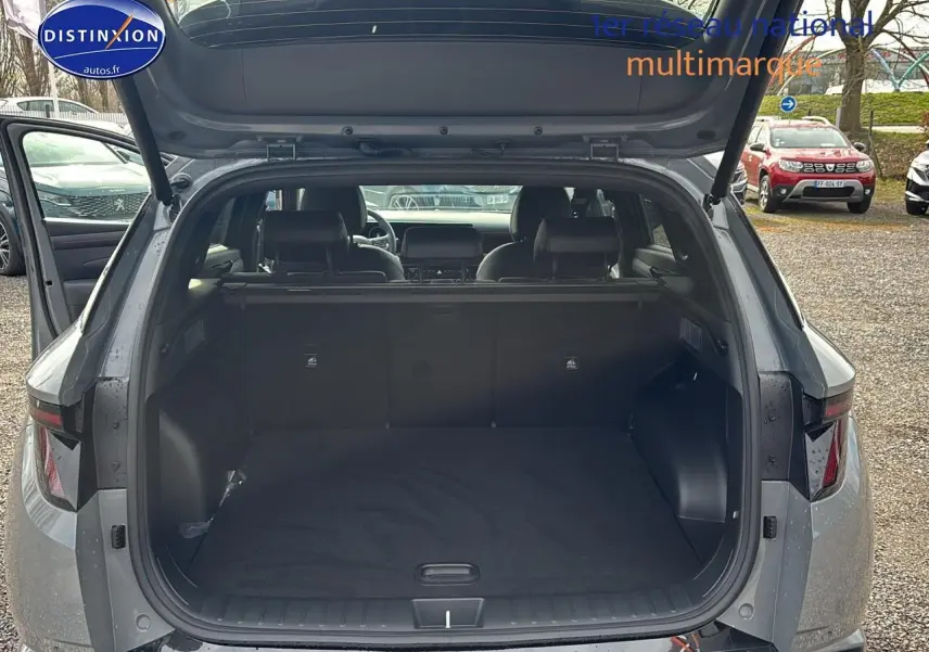 Vue arrière du Hyundai Tucson 2026 gris shadow avec coffre ouvert et intérieur spacieux visible.