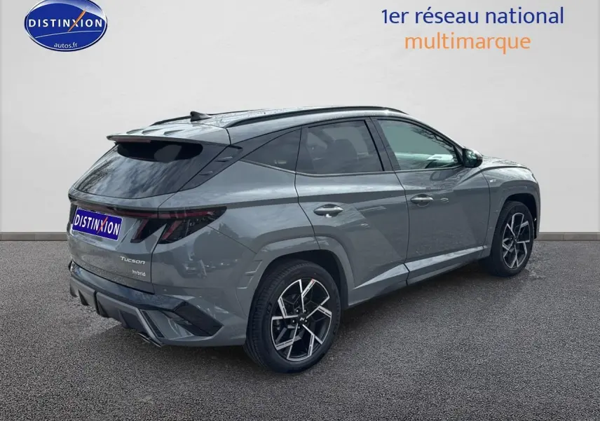 Vue 3/4 arrière droite du Hyundai Tucson 2026 gris Shadow avec jantes alliage 19 pouces et toit noir.