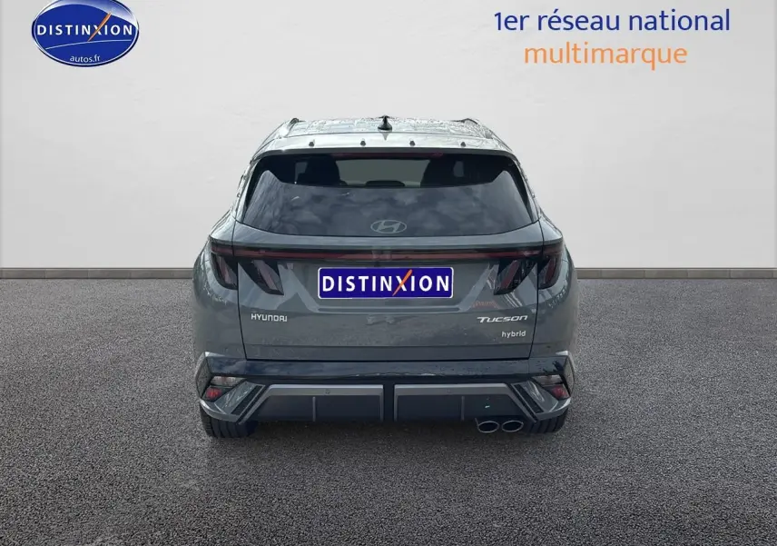 Vue arrière d'un Hyundai Tucson hybride gris shadow avec feux arrière LED et double sortie d'échappement à droite.