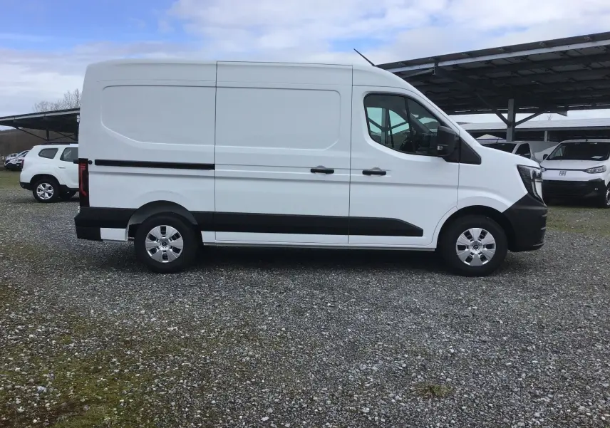 Vue de profil côté gauche d’un Renault Master blanc, fourgon utilitaire avec protections noires sur les bas de caisse.
