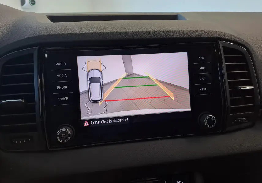 Écran central du Skoda Karoq 2025 blanc lune montrant la caméra de recul avec guidage de stationnement.
