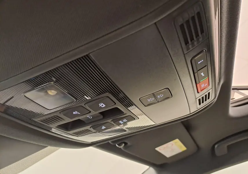 Plafonnier noir avec commandes d’éclairage et toit ouvrant partiel dans un Skoda Karoq Blanc Lune 2025 Sportline.