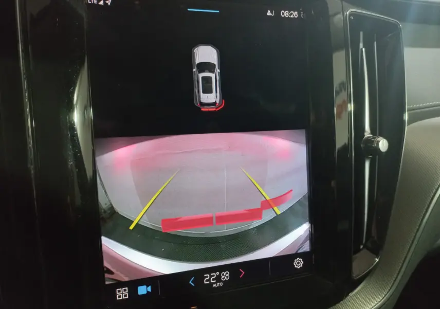 Écran tactile intérieur montrant la caméra de recul avec guidage et alertes du Volvo XC60 gris clair, version Inscription.