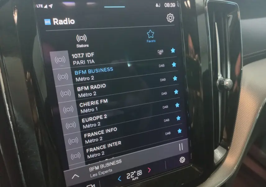 Écran tactile central affichant les stations radio dans l'habitacle d'un Volvo XC60 gris clair de 2022.