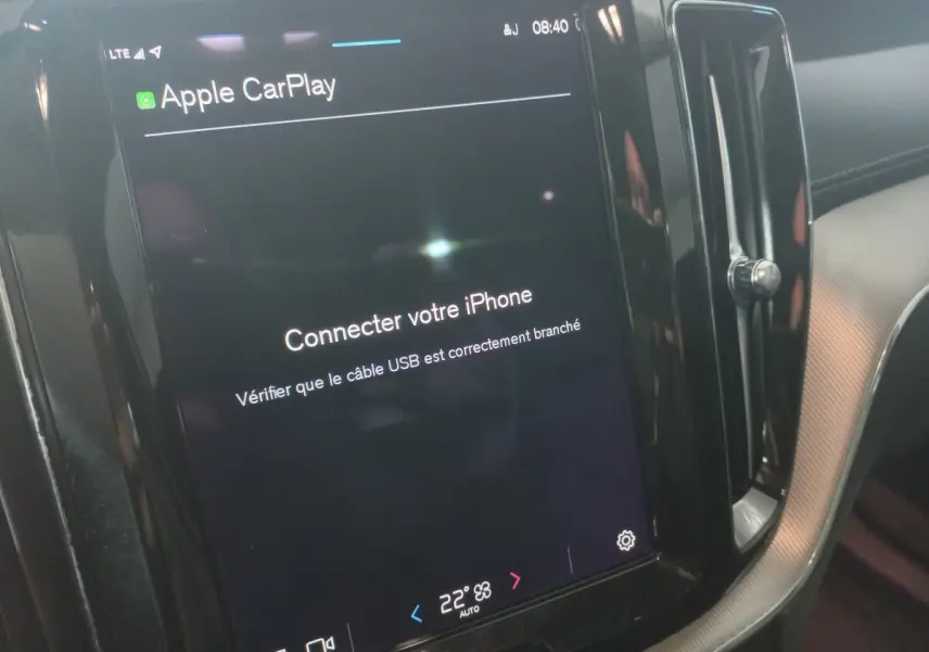 Écran tactile central du tableau de bord du Volvo XC60 gris clair, affichant la connexion Apple CarPlay.