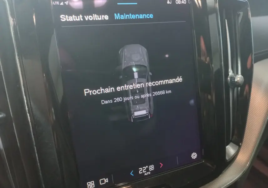 Écran tactile central du Volvo XC60 gris clair affichant le rappel de maintenance et la température à 22°C.