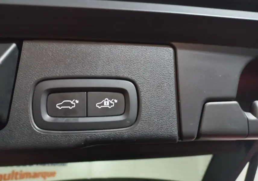 Gros plan sur les boutons d'ouverture et de verrouillage électrique du coffre du Volvo XC60 gris clair, version 2022.