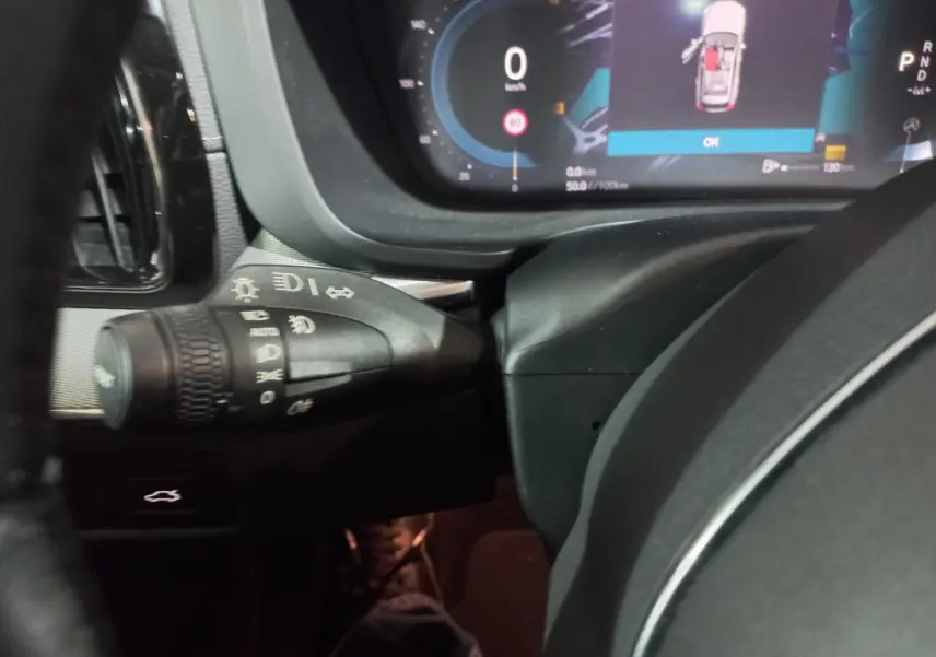 Gros plan sur la commande des phares et le tableau de bord numérique du Volvo XC60 gris clair, version 2022.