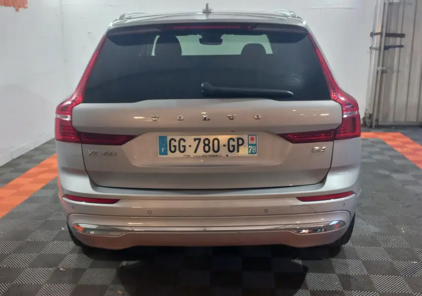 Vue arrière d'un Volvo XC60 gris clair avec feux LED caractéristiques et plaque d'immatriculation française visible.