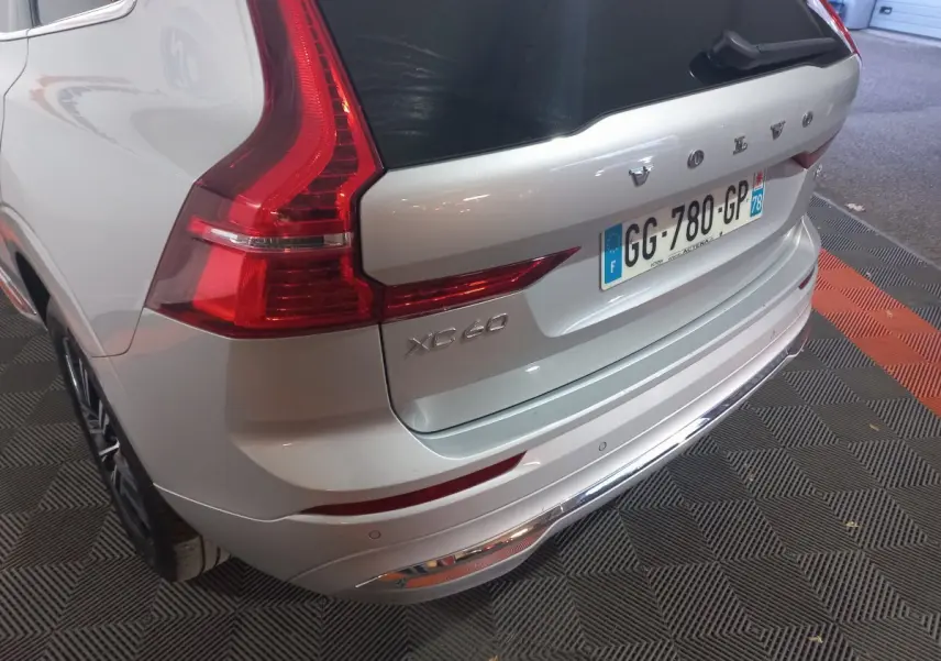 Vue 3/4 arrière droite d'un Volvo XC60 gris clair avec feux arrière LED et plaque d'immatriculation française.